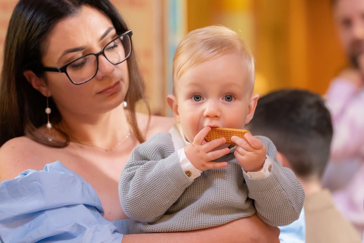 Family blessing moment during a Serbian Orthodox christening ceremony