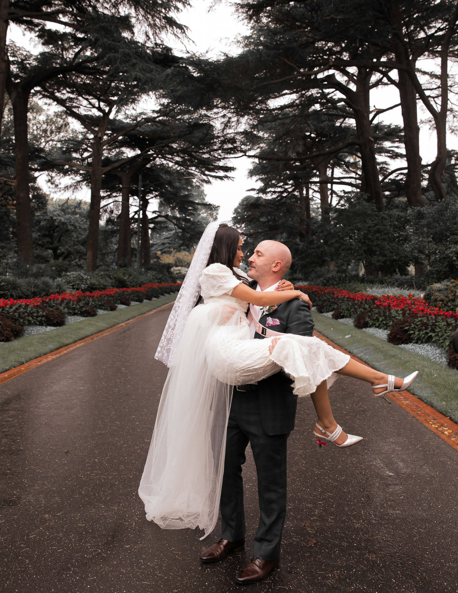 A groom holds his bride in the Melbourne Botanic Gardens, photographed by Royale Photography.
