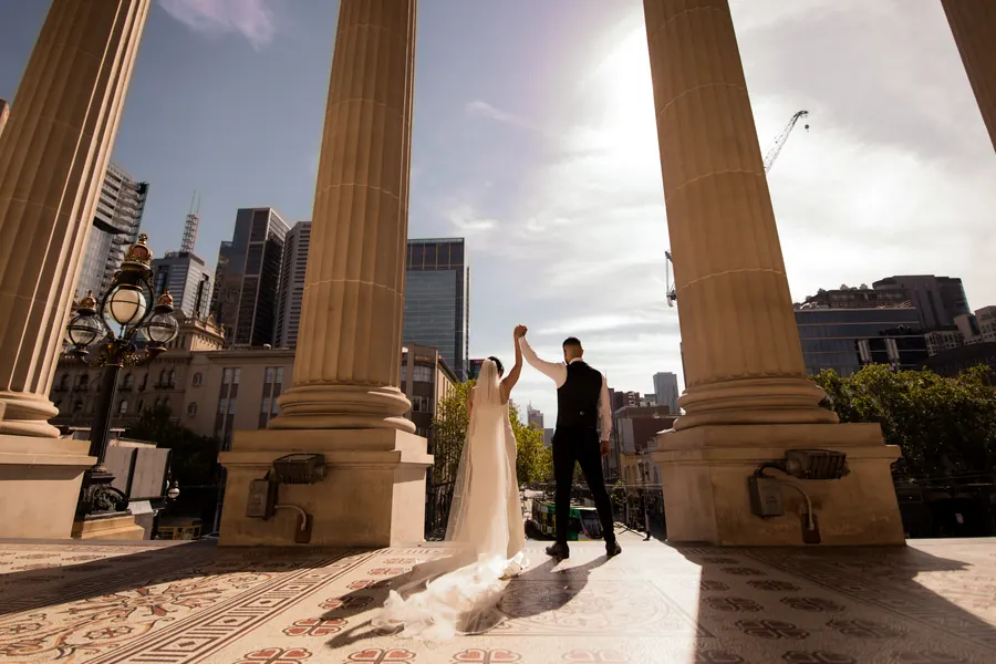 A couple framed beneath grand city archways