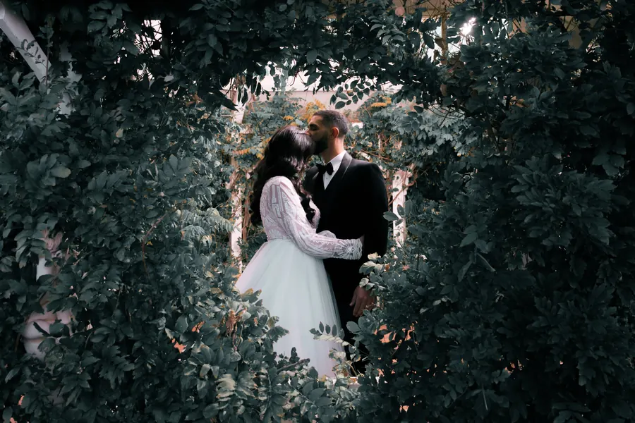 An intimate portrait of a couple among soft forest greenery