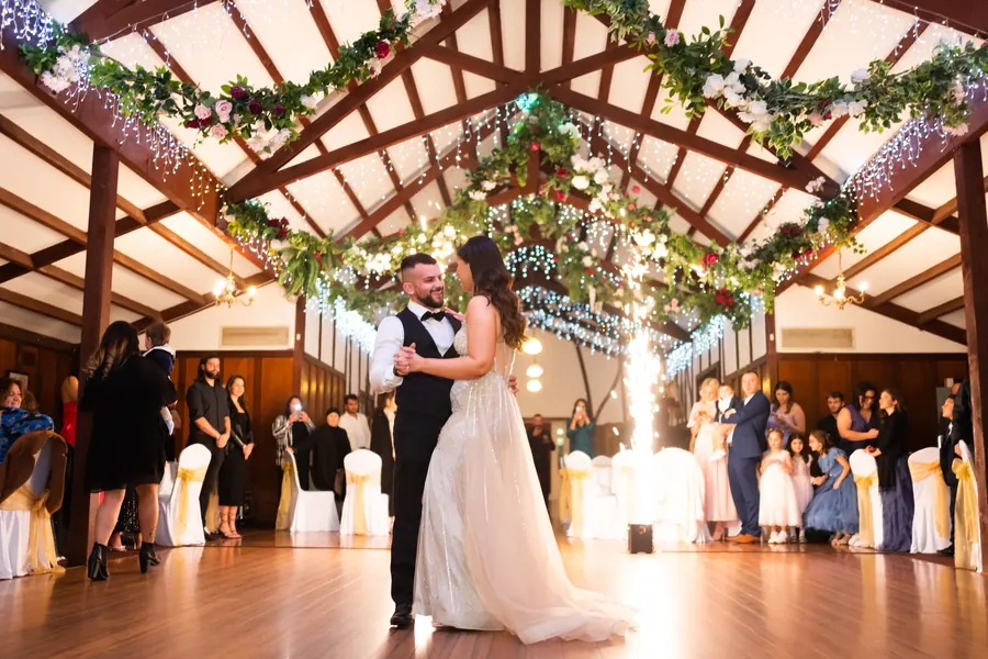 Newlyweds share their first dance in a candlelit reception hall
