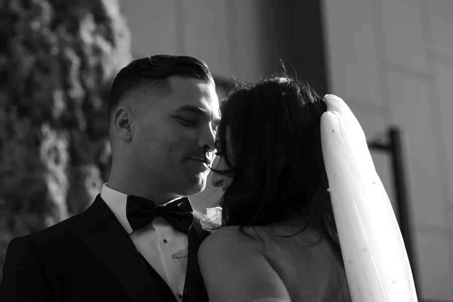 Black and white portrait of a bride and groom sharing a quiet kiss