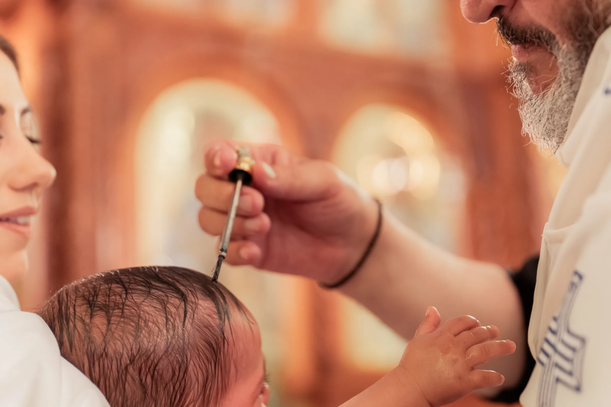 Priest blessing a child during a Melbourne christening ceremony photographed by Royale Photography
