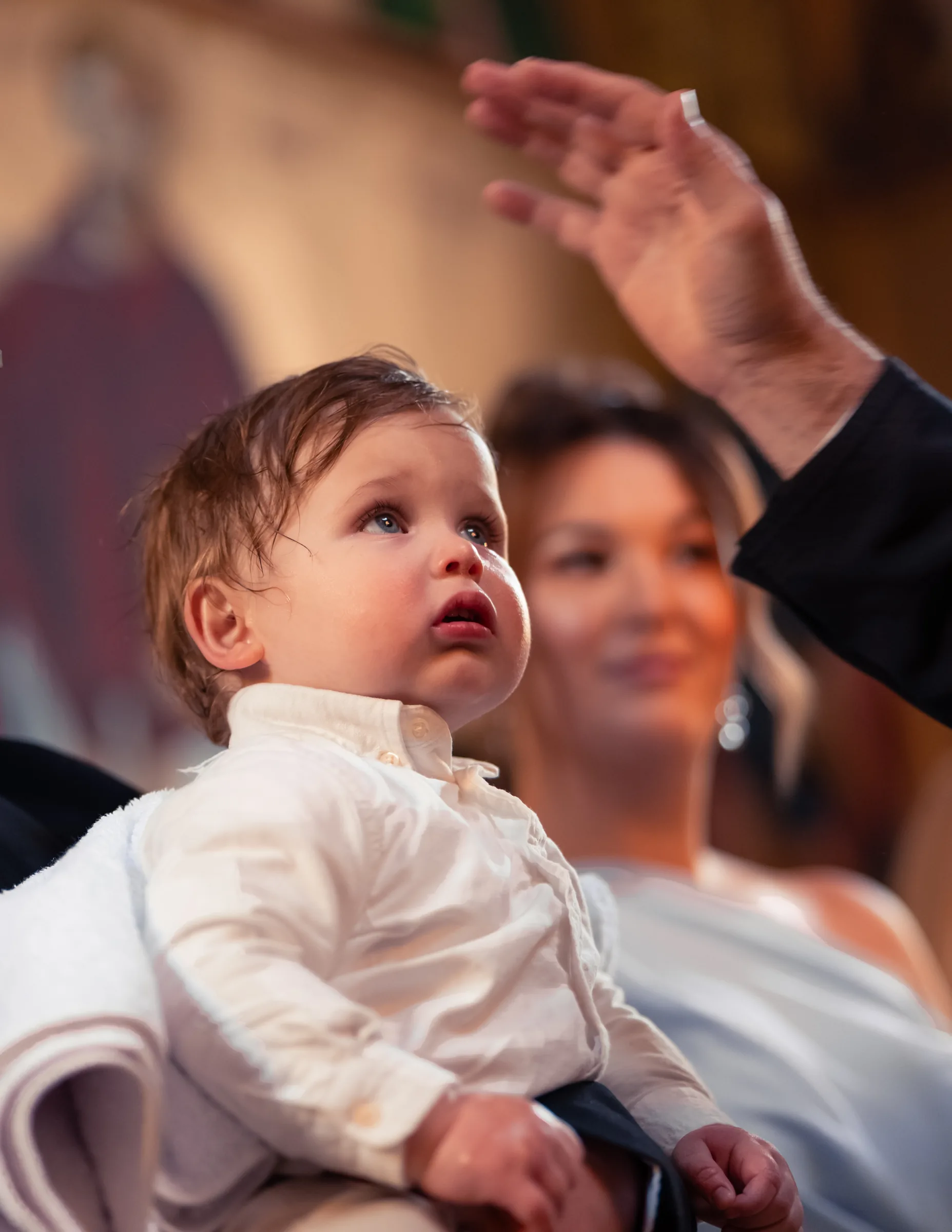 A child looking upward during a christening photographed by Royale Photography